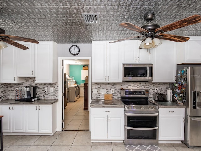 kitchen featuring light tile patterned floors, appliances with stainless steel finishes, ceiling fan, and washing machine and clothes dryer