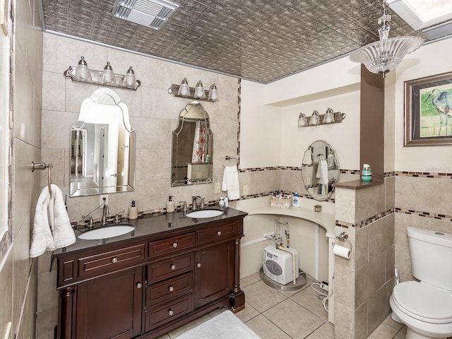 bathroom with vanity, a notable chandelier, tile patterned floors, toilet, and tile walls