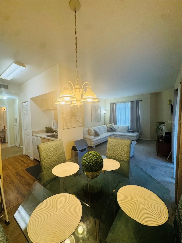 dining space featuring dark hardwood / wood-style floors, sink, and a chandelier