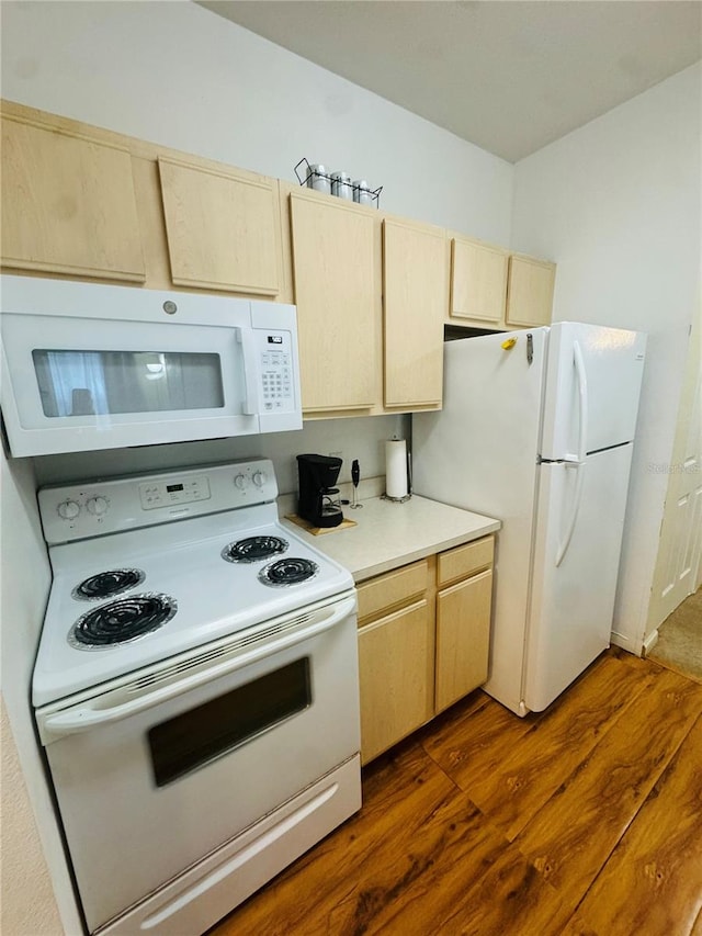 kitchen with light brown cabinets, white appliances, and dark wood-type flooring