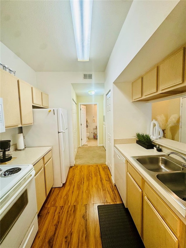 kitchen featuring light brown cabinets, sink, white appliances, and hardwood / wood-style flooring