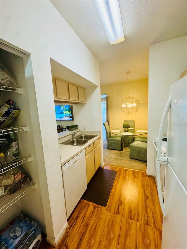 kitchen with white appliances, sink, light brown cabinets, decorative light fixtures, and light hardwood / wood-style flooring