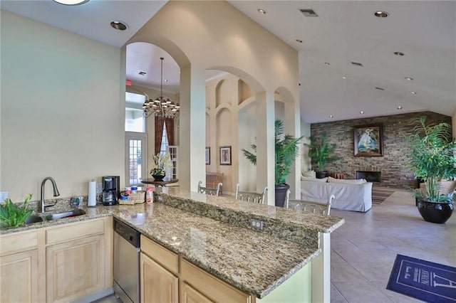 kitchen featuring kitchen peninsula, dishwasher, a towering ceiling, and sink