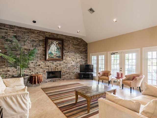 living room featuring a stone fireplace, light tile patterned floors, high vaulted ceiling, and french doors