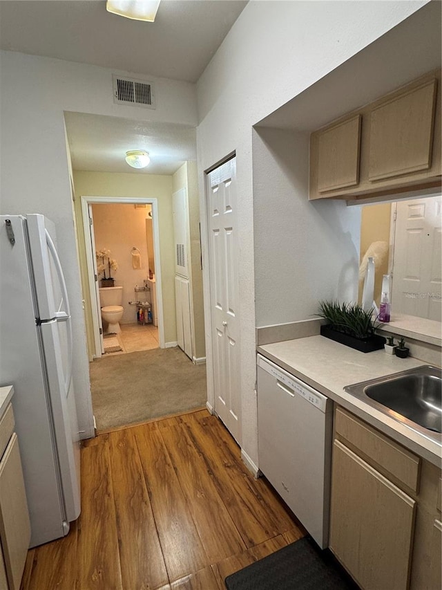 kitchen with white appliances, dark wood-type flooring, and sink