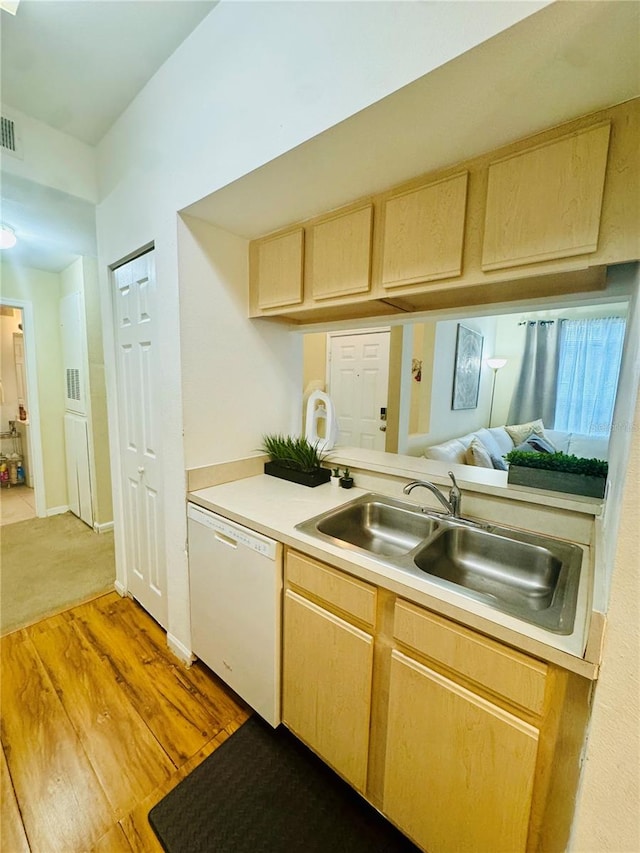 kitchen featuring white dishwasher, light brown cabinets, light wood-type flooring, and sink