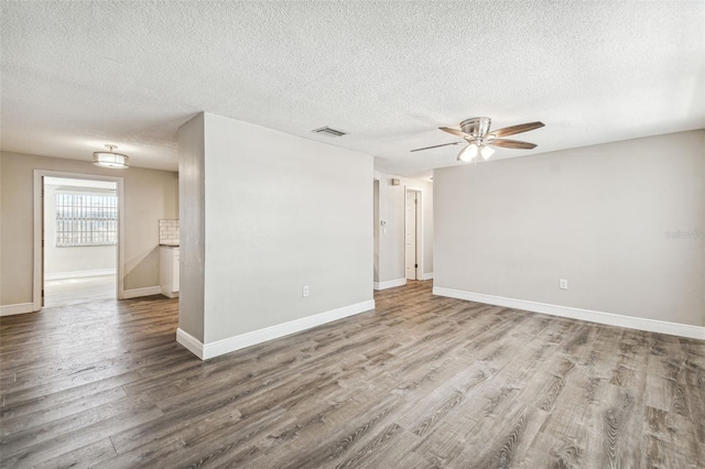 unfurnished room with a textured ceiling, hardwood / wood-style floors, and ceiling fan