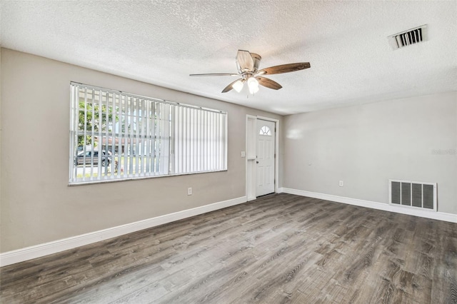 unfurnished room featuring hardwood / wood-style floors, ceiling fan, and a textured ceiling