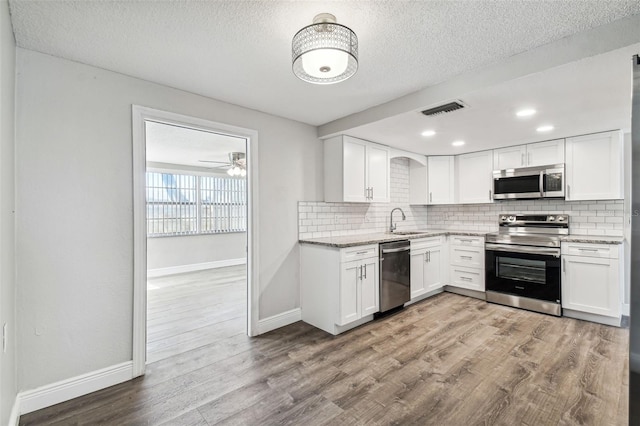 kitchen featuring white cabinets, stainless steel appliances, and light hardwood / wood-style flooring