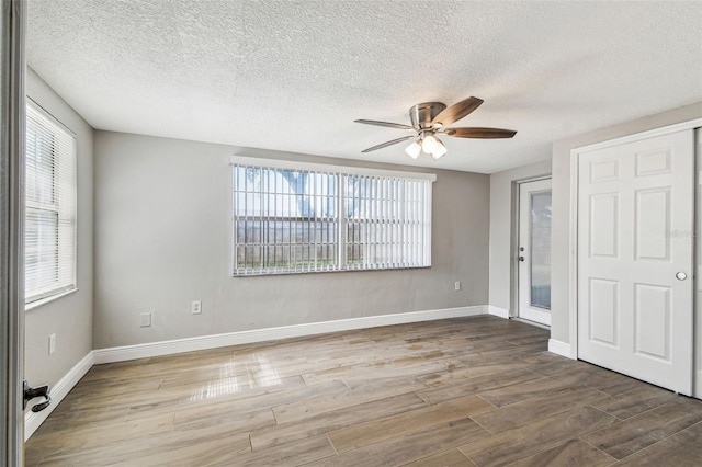 unfurnished bedroom with ceiling fan, wood-type flooring, and a textured ceiling