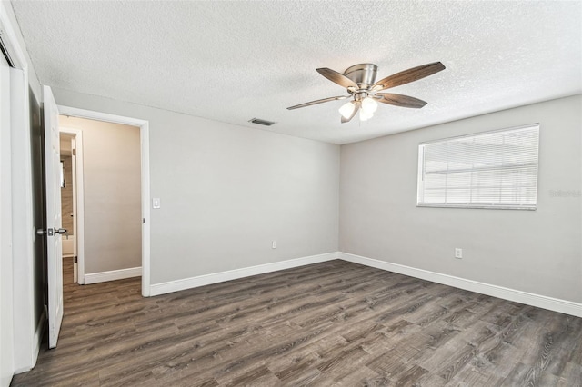 empty room with ceiling fan, a textured ceiling, and dark hardwood / wood-style floors