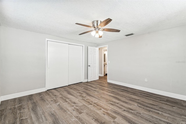 unfurnished bedroom with a closet, hardwood / wood-style floors, ceiling fan, and a textured ceiling