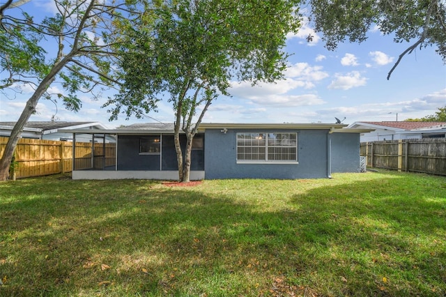 rear view of property featuring a lawn and a sunroom