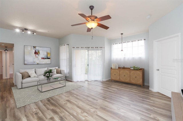 unfurnished living room featuring track lighting, light hardwood / wood-style floors, and ceiling fan