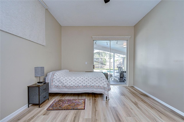 bedroom with ceiling fan, light hardwood / wood-style flooring, lofted ceiling, and access to outside