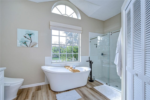 full bathroom featuring wood-type flooring, toilet, separate shower and tub, a textured ceiling, and vanity