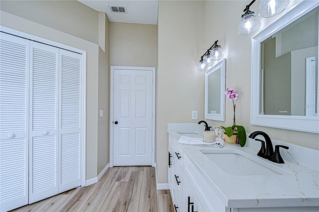 bathroom with wood-type flooring, a textured ceiling, and vanity