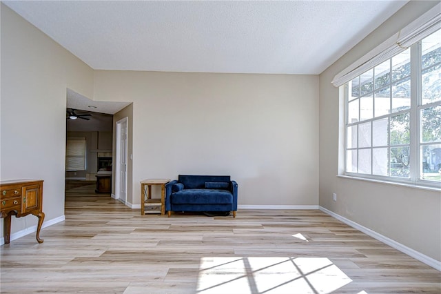 sitting room featuring a textured ceiling, light hardwood / wood-style floors, and ceiling fan