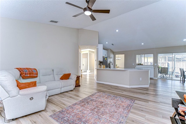 living room featuring light wood-type flooring, lofted ceiling, and ceiling fan