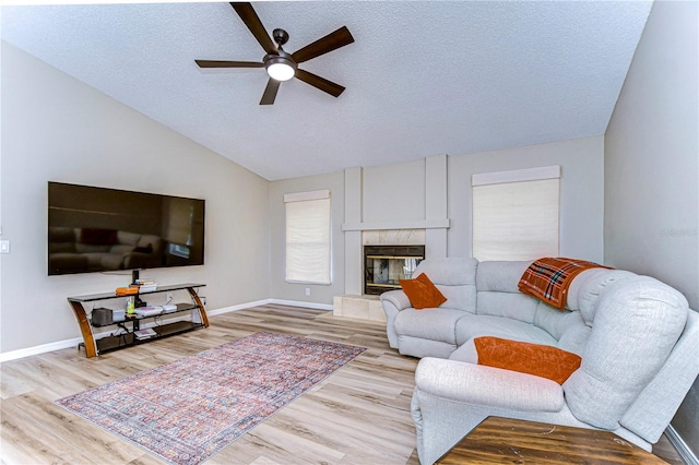 living room with light wood-type flooring, lofted ceiling, and ceiling fan