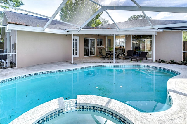 view of swimming pool featuring glass enclosure and a patio