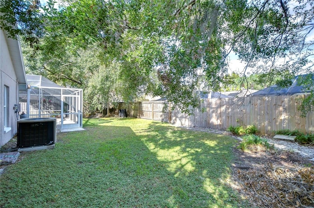 view of yard with central air condition unit and a lanai