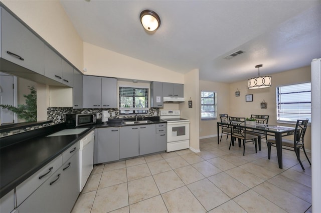 kitchen with a wealth of natural light, lofted ceiling, and white appliances