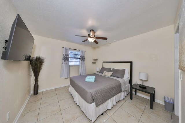 tiled bedroom featuring ceiling fan