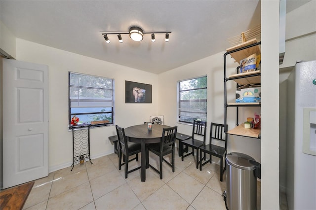 dining room with rail lighting and light tile patterned floors