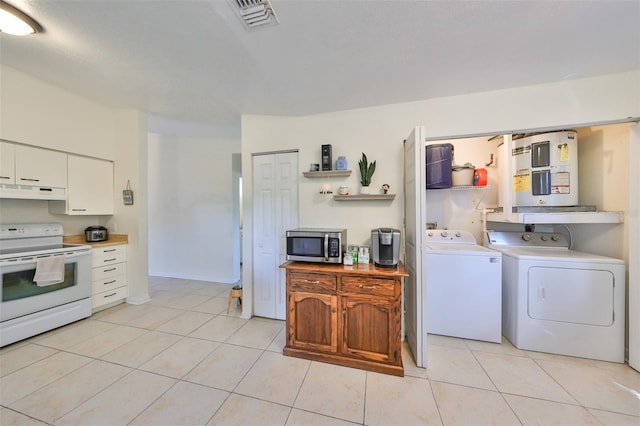 kitchen with electric stove, water heater, light tile patterned floors, washer and clothes dryer, and white cabinetry