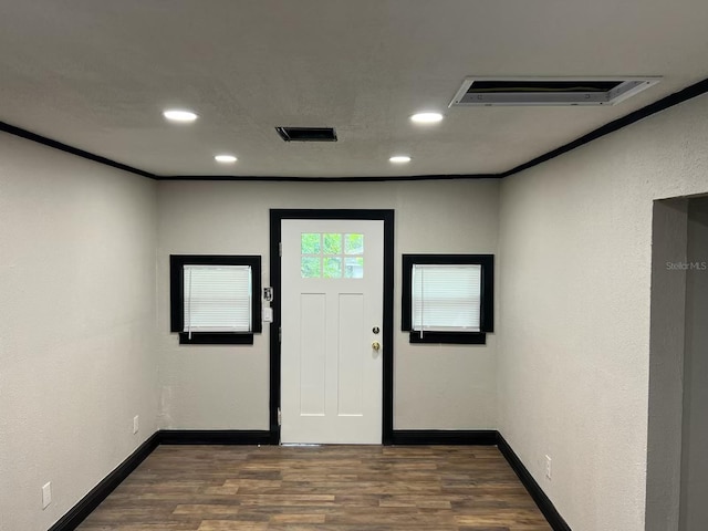 entrance foyer featuring dark wood-type flooring and crown molding