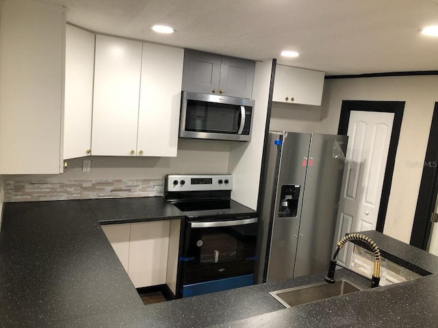 kitchen featuring crown molding, appliances with stainless steel finishes, decorative backsplash, sink, and white cabinets