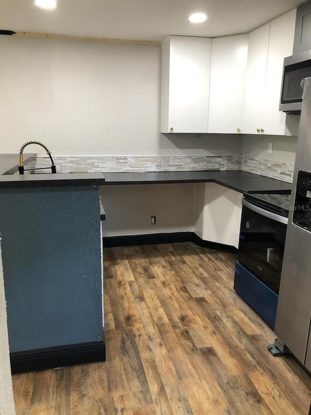 kitchen with white cabinetry, appliances with stainless steel finishes, and dark wood-type flooring