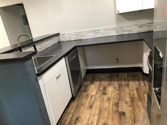 kitchen featuring white cabinetry, dark hardwood / wood-style floors, sink, dishwasher, and kitchen peninsula