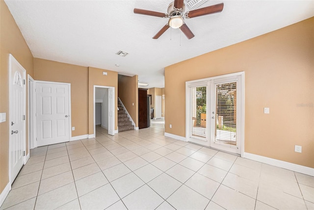 unfurnished room featuring a textured ceiling, light tile patterned floors, and ceiling fan