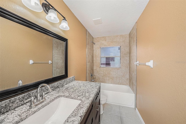 full bathroom featuring vanity, a textured ceiling, tiled shower / bath combo, tile patterned flooring, and toilet