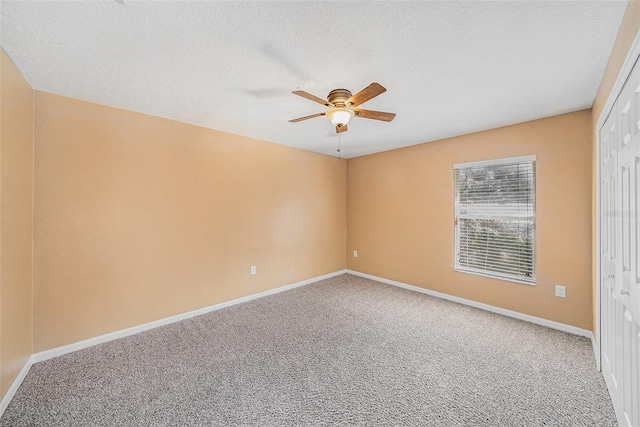 carpeted spare room featuring a textured ceiling and ceiling fan