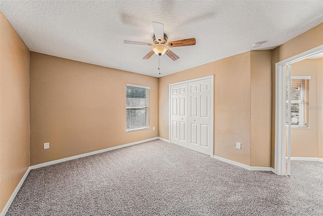 unfurnished bedroom with a closet, carpet, a textured ceiling, and ceiling fan