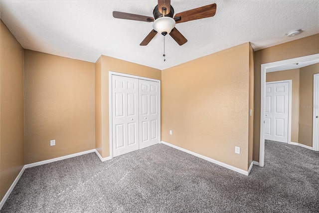 unfurnished bedroom featuring a closet, dark colored carpet, and ceiling fan