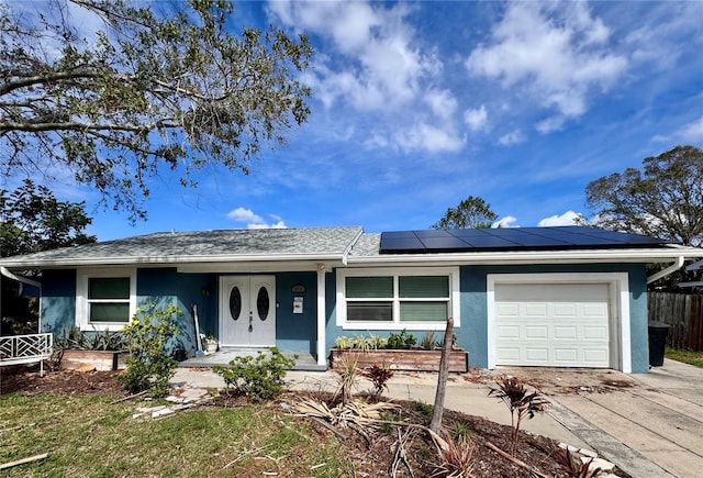 ranch-style house with a garage, solar panels, and a porch