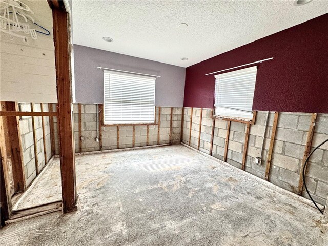 unfurnished room with a textured ceiling