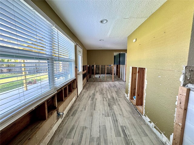 hallway featuring wood-type flooring and a textured ceiling