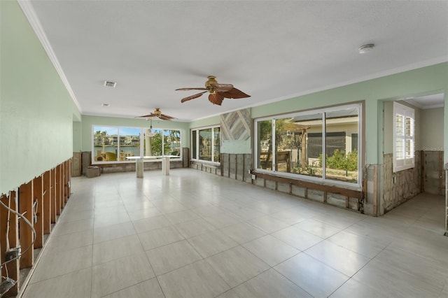 empty room featuring visible vents, a wealth of natural light, and ornamental molding