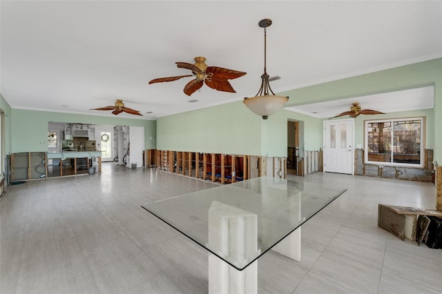 unfurnished living room with crown molding, plenty of natural light, and a ceiling fan