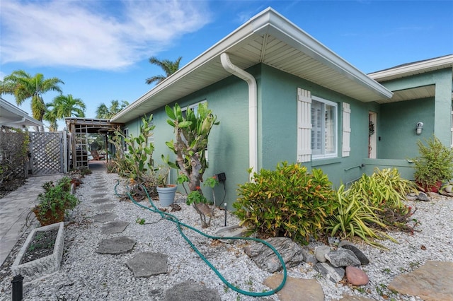 view of home's exterior featuring fence, a gate, and stucco siding