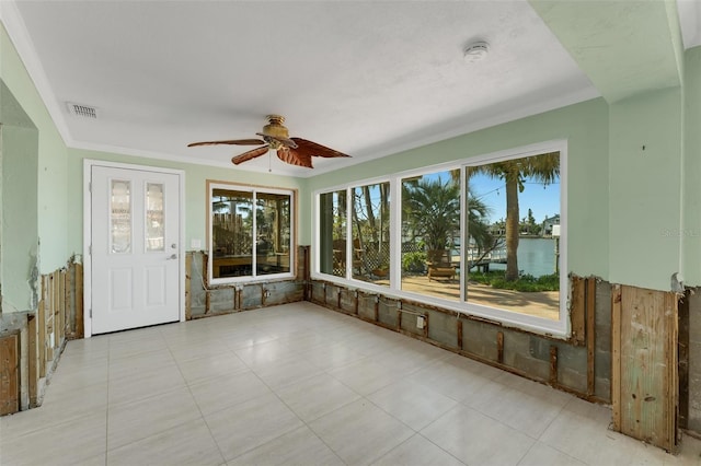 unfurnished sunroom featuring ceiling fan and a water view