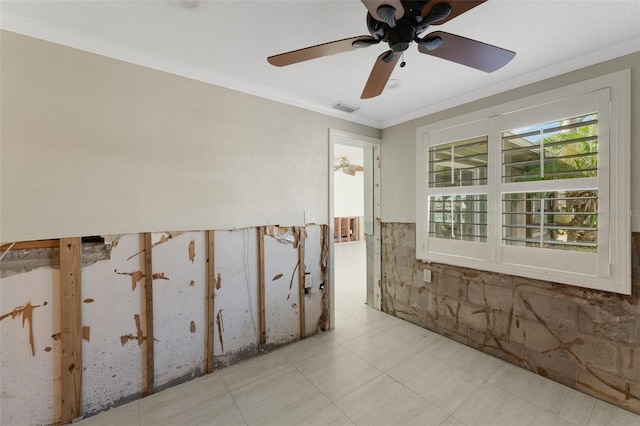 empty room featuring ornamental molding, a wainscoted wall, and visible vents