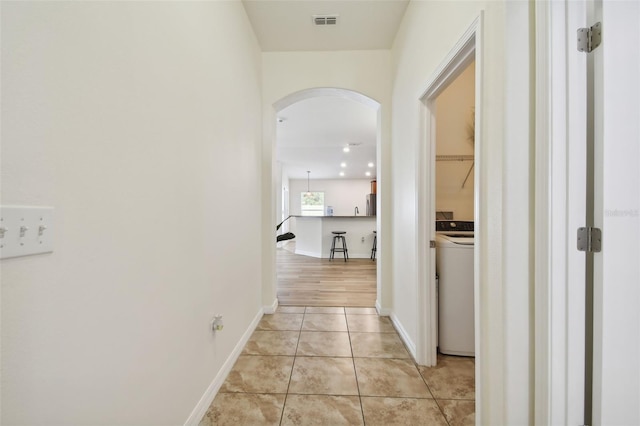 corridor featuring light hardwood / wood-style floors and washer / dryer