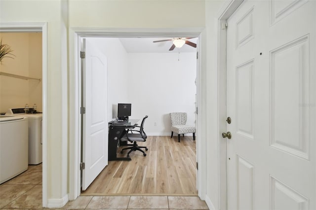 office space featuring light wood-type flooring, ceiling fan, and separate washer and dryer