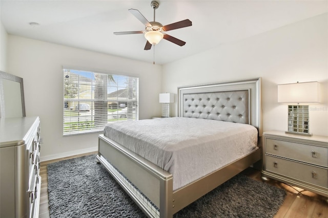 bedroom with dark hardwood / wood-style flooring and ceiling fan